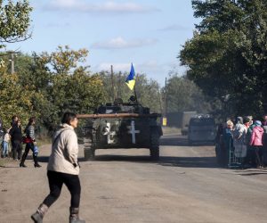 epa10227261 A Ukrainian APC drives by as resident wait for a truck carrying humanitarian aid in the village of Kapytolyvka, east of Izyum, Kharkiv Oblast, Ukraine, 06 October 2022. 
Russian troops withdrew from the occupied territory in the northeast. On 24 February 2022, Russian troops entered Ukrainian territory starting an armed conflict that has provoked destruction and a humanitarian crisis.  EPA/ATEF SAFADI