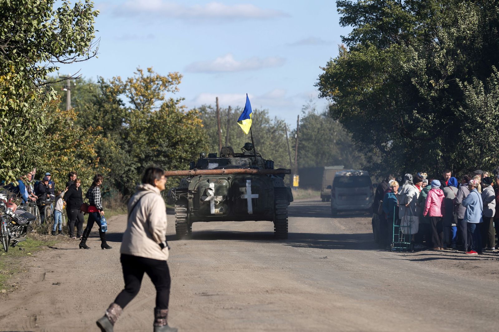 epa10227261 A Ukrainian APC drives by as resident wait for a truck carrying humanitarian aid in the village of Kapytolyvka, east of Izyum, Kharkiv Oblast, Ukraine, 06 October 2022. 
Russian troops withdrew from the occupied territory in the northeast. On 24 February 2022, Russian troops entered Ukrainian territory starting an armed conflict that has provoked destruction and a humanitarian crisis.  EPA/ATEF SAFADI