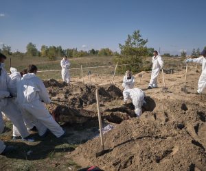 epa10229372 Forensic technicians work at a burial site near the recently recaptured city of Lyman, Donetsk area, Ukraine, 07 October 2022. A burial site with more than 50 graves was found after Ukrainian troops recaptured the town of Lyman. Ukrainian authorities have started exhuming and indentifying the bodies of the partially unmarked graves. Russian troops entered Ukraine territory on 24 February 2022, starting a conflict that has provoked destruction and a humanitarian crisis.  EPA/YEVGEN HONCHARENKO