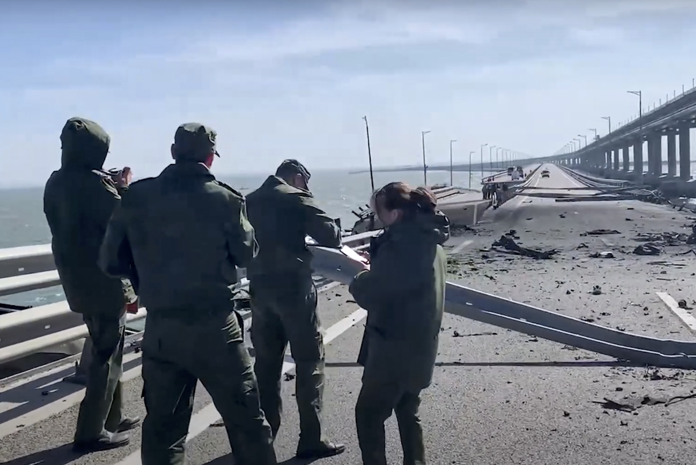 epa10230384 A still image taken from handout video provided by the Russian Investigative committee shows Russian investigators work on a collapsed part of the Kerch Strait bridge in Crimea, 08 October 2022. According to Russian authorities, "an explosion was set off at a cargo vehicle on the motorway part of the Crimean bridge on the side of the Taman peninsula, which set fire to seven fuel tanks of a train that was en route to the Crimean peninsula. Two motorway sections of the bridge partially collapsed."  EPA/RUSSIAN INVESTIGATIVE COMMITEE HANDOUT  HANDOUT EDITORIAL USE ONLY/NO SALES