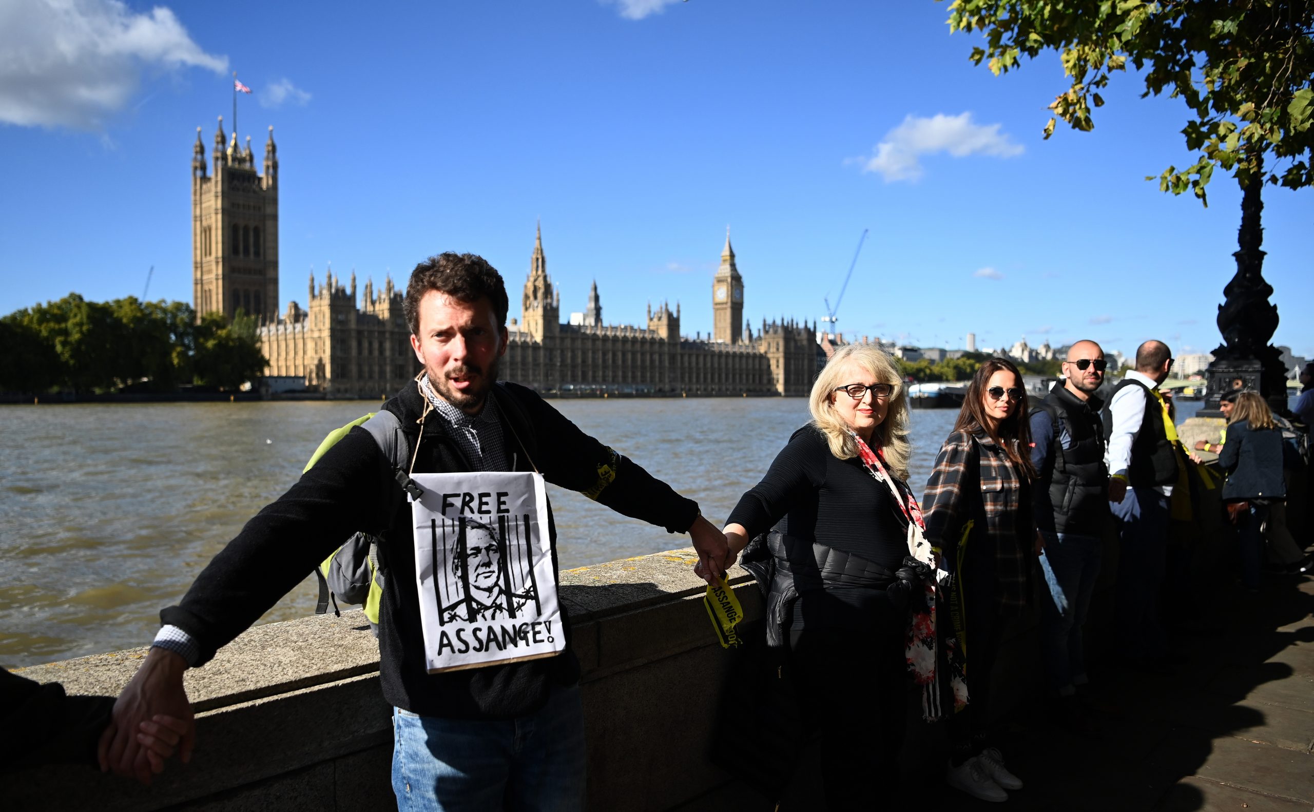 epa10230689 Supporters of Wikileaks founder Julian Assange form a human chain around the British parliament in London, Britain, 08 October 2022. The British government has announced it has agreed to extradite Assange to the United States.  EPA/ANDY RAIN