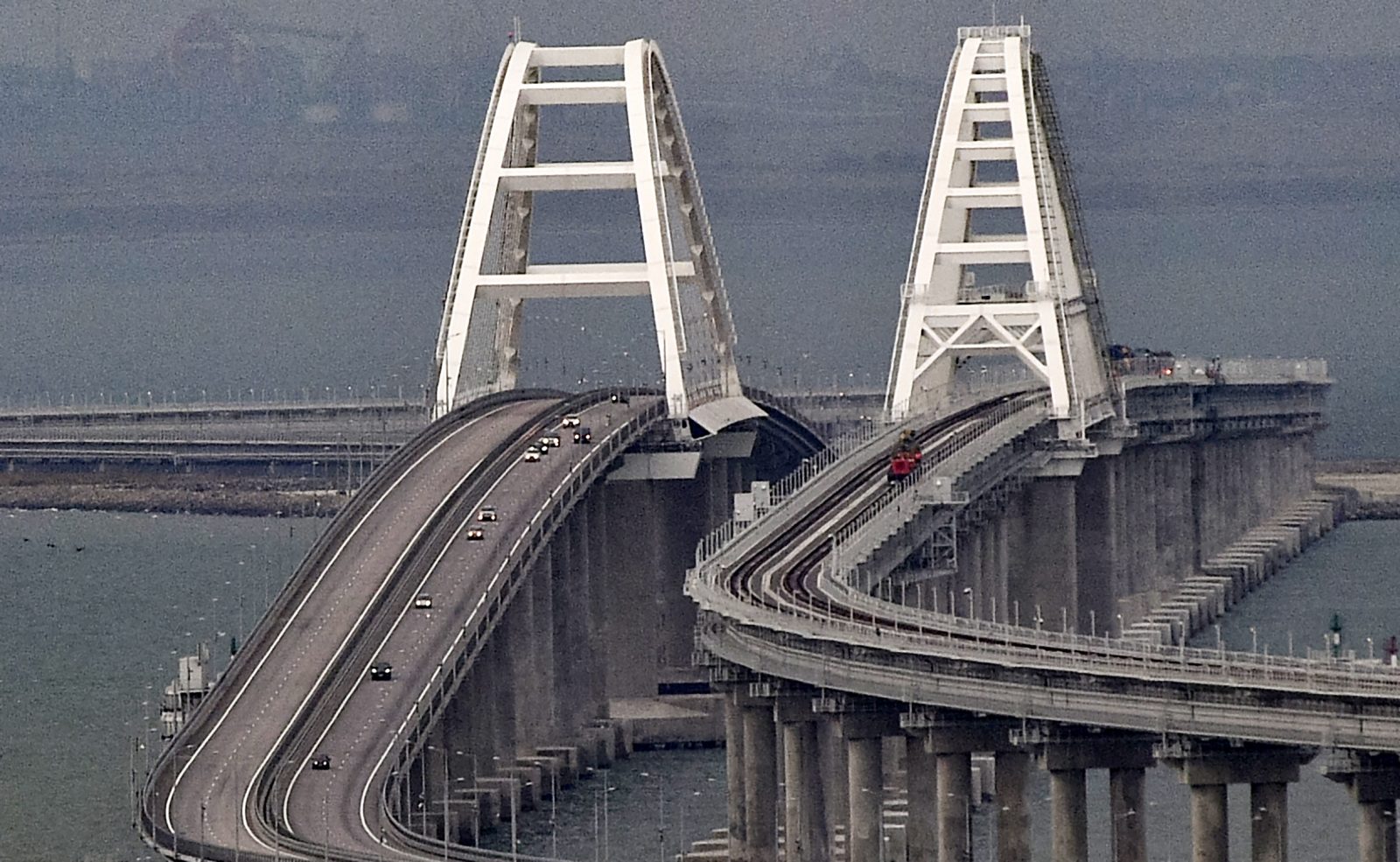 epa10232212 Cars move on the Kerch Strait bridge in Crimea, 09 October 2022. Automobile traffic on the undamaged part of the Crimean bridge has been restored, the head of the annexed Crimea Sergey Aksyonov announced. The previous day, Russian authorities said that "an explosion was set off at a cargo vehicle on the motorway part of the Crimean bridge on the side of the Taman peninsula, which set fire to seven fuel tanks of a train that was en route to the Crimean peninsula. Two motorway sections of the bridge partially collapsed."  EPA/STRINGER