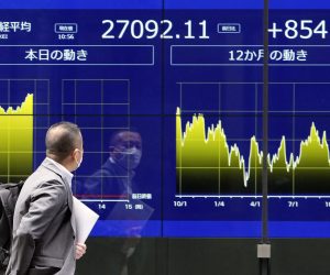 epa10242558 A passerby walks past a stock market indicator board in Tokyo, Japan, 14 October 2022. Tokyo's Nikkei stock index jumped more than 3 percent during the morning trading session following overnight gains at New York’s Wall Street.  EPA/FRANCK ROBICHON