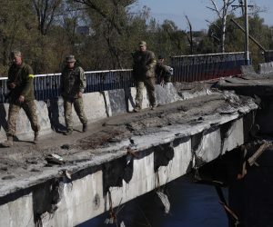 epa10245757 Ukrainians soldiers cross a damaged bridge in the recently recaptured city of Kupiansk, east of Kharkiv, northeastern Ukraine, 15 October 2022. The Ukrainian army pushed Russian troops from occupied territory in the northeast of the country in counterattacks. Kharkiv and surrounding areas have been the target of heavy shelling since February 2022, when Russian troops entered Ukraine starting a conflict that has provoked destruction and a humanitarian crisis.  EPA/ATEF SAFADI