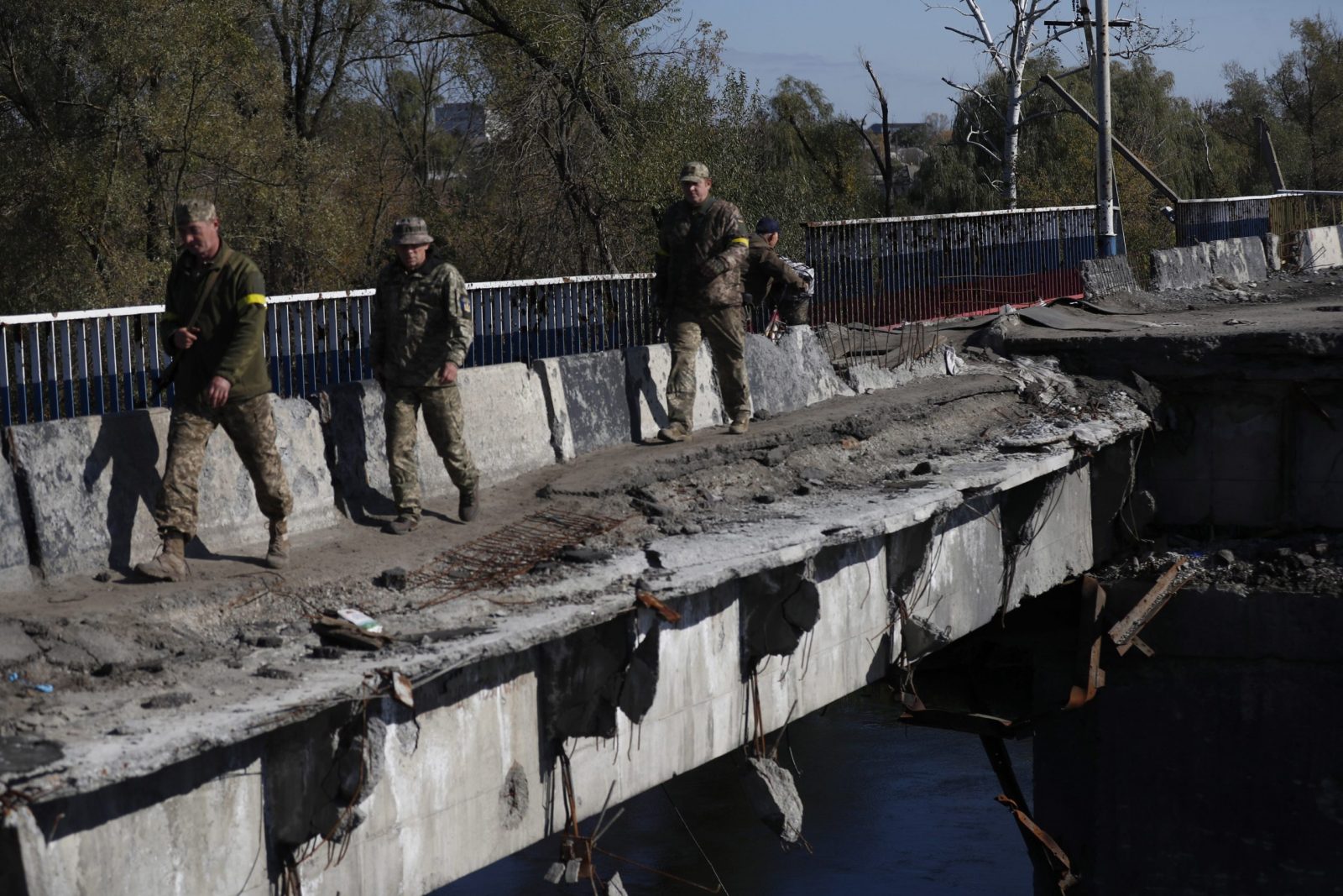 epa10245757 Ukrainians soldiers cross a damaged bridge in the recently recaptured city of Kupiansk, east of Kharkiv, northeastern Ukraine, 15 October 2022. The Ukrainian army pushed Russian troops from occupied territory in the northeast of the country in counterattacks. Kharkiv and surrounding areas have been the target of heavy shelling since February 2022, when Russian troops entered Ukraine starting a conflict that has provoked destruction and a humanitarian crisis.  EPA/ATEF SAFADI