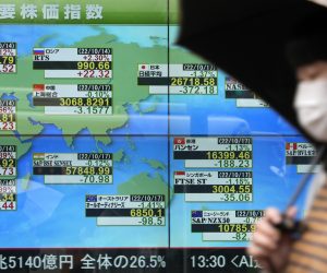 epa10248314 A person walks past a screen displaying stock markets around the world, in Tokyo, Japan, 17 October 2022. The yen fell against the US dollar to reach the upper 148 range.  EPA/FRANCK ROBICHON