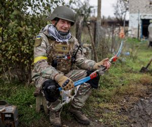 epa10264733 A Ukrainian soldier smiles with a crossbow he found during search for explosives at a recapture area in the north of Kherson, Ukraine, 25 October 2022. Russian troops on 24 February entered Ukrainian territory, starting a conflict that has provoked destruction and a humanitarian crisis.  EPA/HANNIBAL HANSCHKE