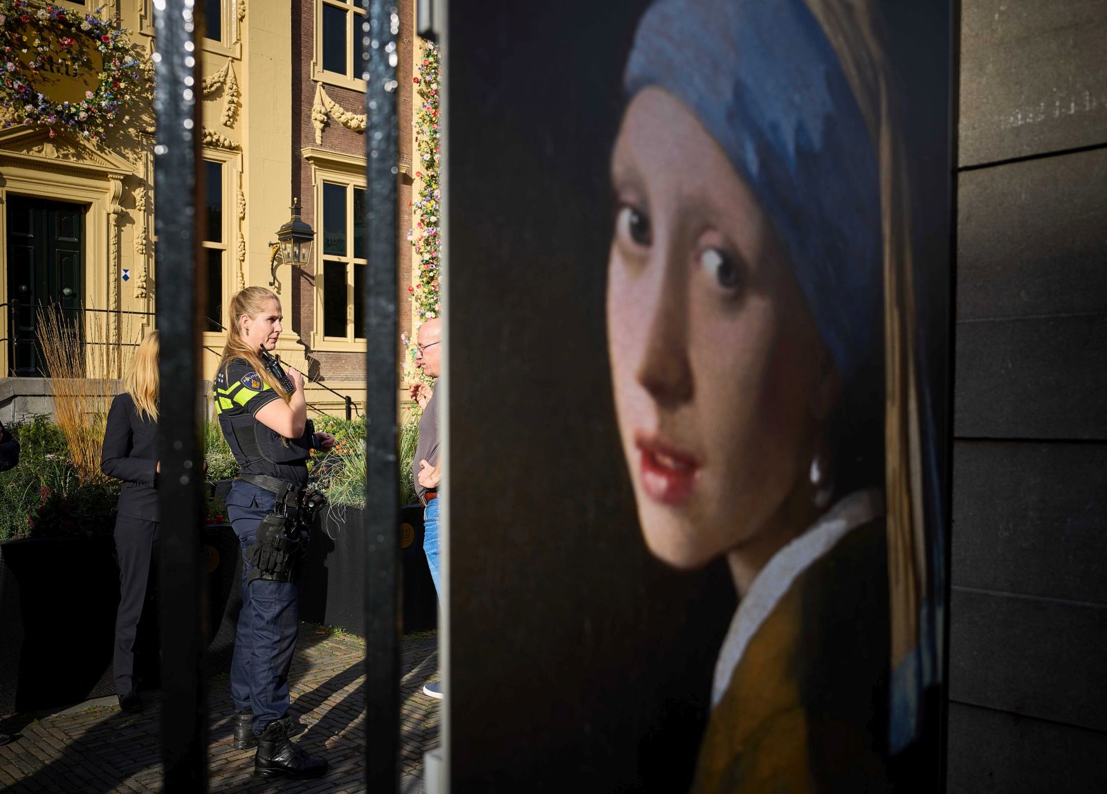 epa10269111 A police officer (L) stands outside the Mauritshuis museum, where three people were arrested for attempting to smudge Vermeer's painting 'Girl with a Pearl Earring', currently exhibited there, in The Hague, Netherlands, 27 October 2022. They were wearing shirts from the Just Stop Oil campaign group, whose members are responsible for recent acts of vandalism - such as throwing soup at paintings, sports cars and luxury shop windows across Europe - in an attempt to raise awareness about their protest against fossil fuels.  EPA/PHIL NIJHUIS