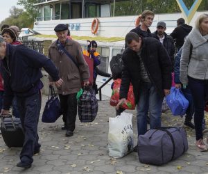 epa10265062 Kherson residents evacuated from Kherson carry luggage after their arrival to Oleshky, Kherson region, Ukraine, 25 October 2022. The authorities of the Kherson region announced the mass displacement of residents of several municipalities, including the city of Kherson, to the left bank of the Dnieper. According to the Acting Governor of the region Vladimir Saldo, this is necessary because of the increased frequency of attacks by the Armed Forces of Ukraine, as well as in connection with the threat of flooding of the territories due to the possible destruction of the dam of the Kakhovskaya hydroelectric power station. According to the deputy head of the regional administration Kirill Stremousov, about 32,000 people were transported to the other side of the Dnipro river.  EPA/STRINGER