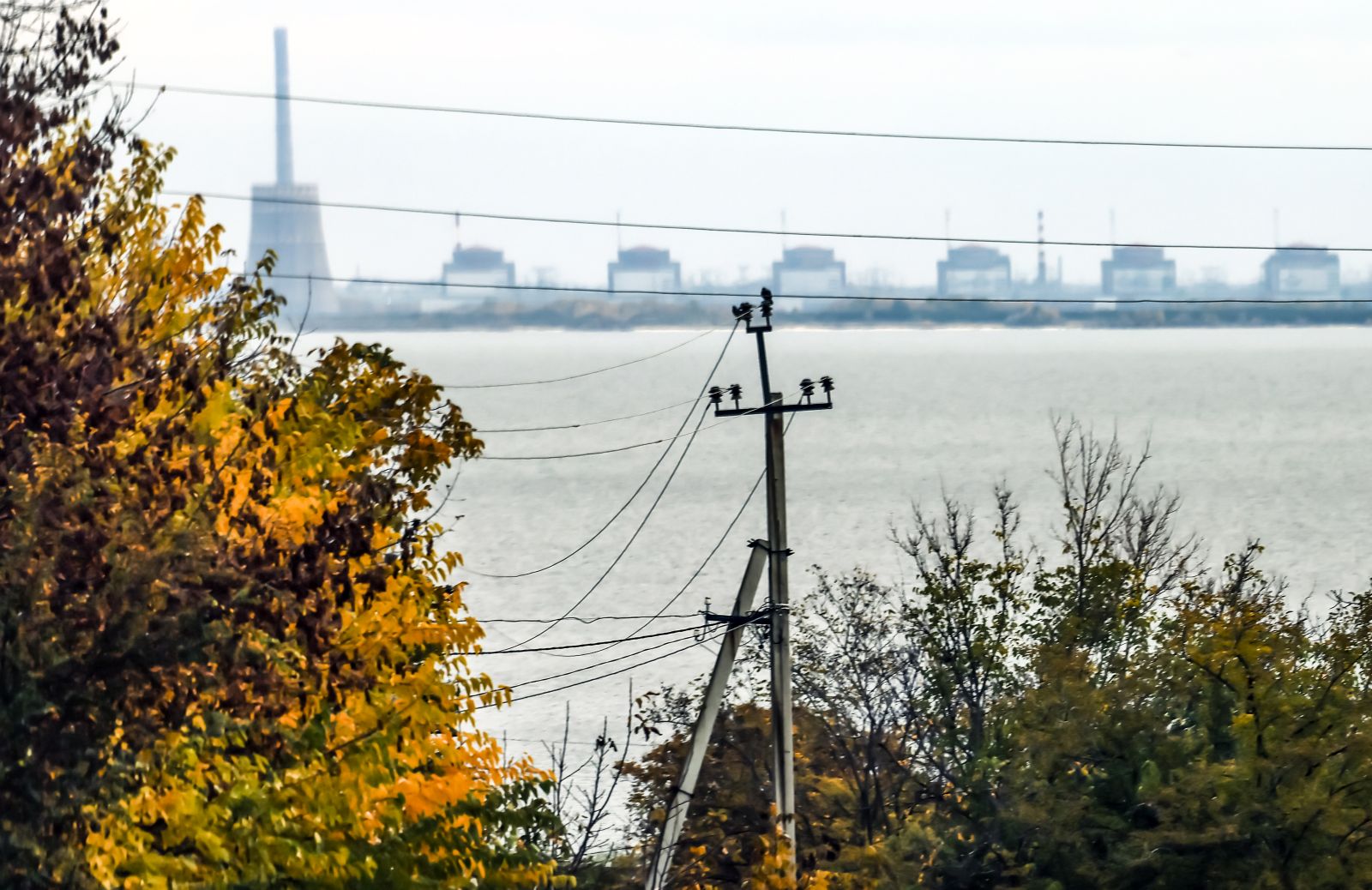 epa10271117 The Zaporizhzhia nuclear power plant (ZNPP) is seen from Nikopol, Ukraine, 28 October 2022. According to a statement by IAEA director general chief Grossi from 28 October 2022, engineers at the ZNPP have been working to stabilize the facility’s external power supplies. The plant has received the power needed to cool the reactors "directly and without interruption from the national grid," the nuclear watchdog's chief said. Russian troops on 24 February entered Ukrainian territory, starting a conflict that has provoked destruction and a humanitarian crisis.  EPA/HANNIBAL HANSCHKE