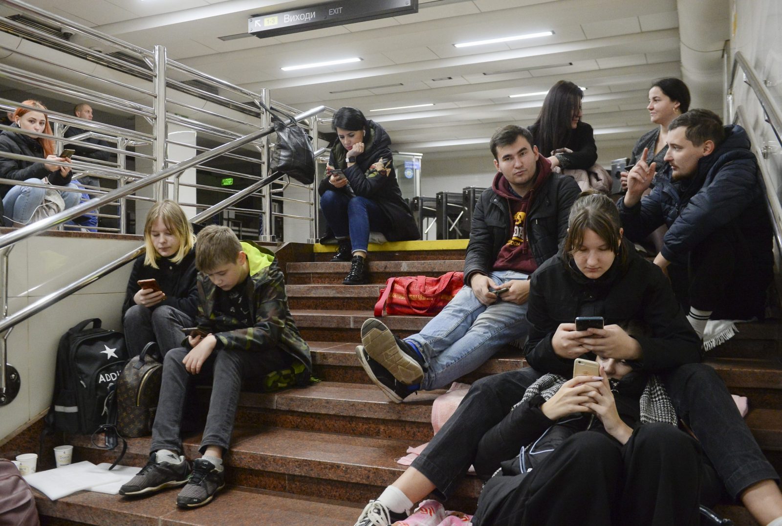 epa10276511 People check their phones as they shelter inside a metro station after a shelling in Kyiv (Kiev), Ukraine, 31 October 2022, amid the ongoing Russian invasion. Explosions have been reported in several districts around Ukraine on 31 October. Kyiv Mayor Vitali Klitschko said on social media that power engineers were working to restore electricity supply after damage to an energy facility that powers around 350,000 apartments in Kyiv. Some parts of the city were left with no water as a result of strikes on critical infrastructure facilities, the mayor added.  EPA/ANDRII NESTERENKO