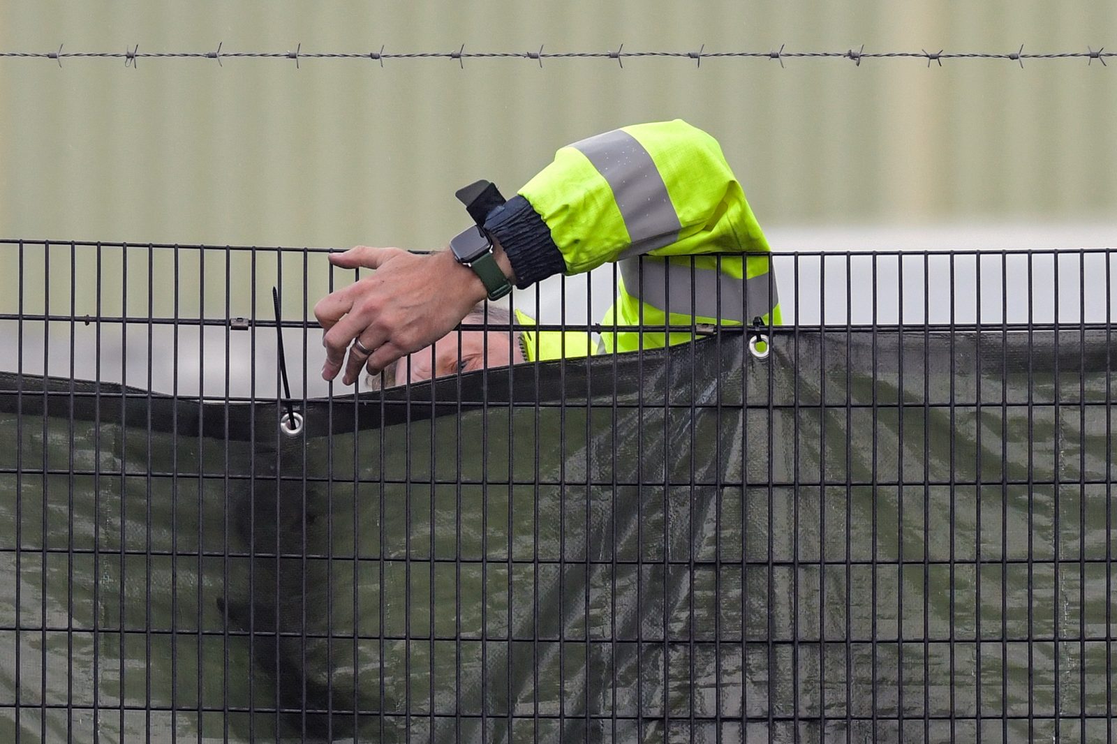 epa10279034 A security guard secures a screen at the outer perimeter at Manston immigration center, a short-term holding facility in Manston, Kent, Britain, 01 November 2022. British Home Secretary Suella Braverman whilst speaking in the House of Commons on 31 October 2022 denied ignoring legal advice to procure more accommodation amid warnings that Manston is dangerously overcrowded. The Chief Inspector of Prisons Charlie Taylor who has recently inspected the center stated that the Home Office needs to 'get a grip' of the situation.  EPA/STUART BROCK