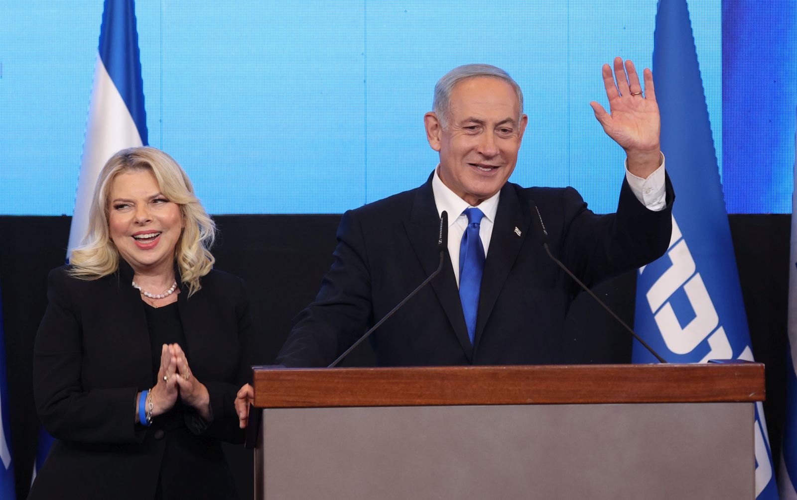 epa10280647 Former Israeli prime minister and leader of the Likud party Benjamin Netanyahu (R) speaks as his wife Sara (L) looks on at the Likud party final election event in Jerusalem, Israel, 01 November 2022.  EPA/ABIR SULTAN