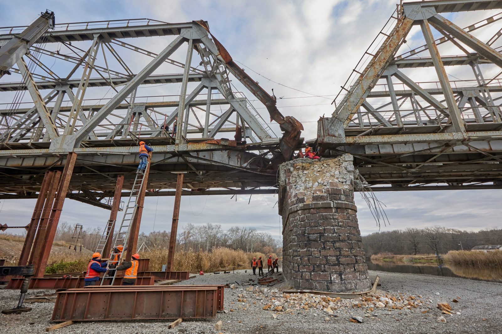 epa10282254 Workers repair a railway bridge after it was damaged in fighting between the Ukrainian and Russian armies in the town of Kupiansk, in Kharkiv region, Ukraine, 02 November 2022. The railway normally connects Kupiansk with Kharkiv which was retaken by the Ukrainian forces in September. Russian troops on 24 February entered Ukrainian territory, starting a conflict that has provoked destruction and a humanitarian crisis.  EPA/SERGIY KOZLOV