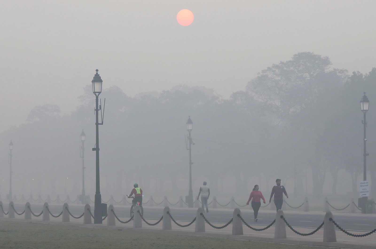 epa10283218 People walk at Rajpath boulevard in New Delhi, as the city is engulfed in heavy smog, India, 03 November 2022. Delhi and National Capital Region's air quality slipped into the 'Severe and Hazardous' category as a result of stubble burning.  EPA/RAJAT GUPTA