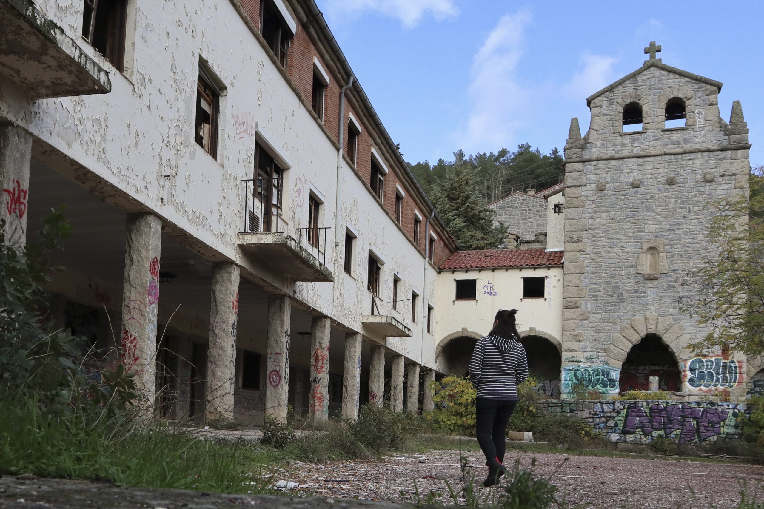 epa10296318 A person walks through the old town of Salto de Castro, Spain, 08 November 2022 (issued 09 November 2022). The town has been uninhabited for over three decades since the hydroelectric plant that was built in the 50's was shut down. The municipality of Fonfria (in Zamora province, central Spain), where Salto de Castro is located, has received with the same proportion of caution as enthusiasm the unusual interest that has aroused the latest offer for the sale of the unoccupied town for 260,000 euros.  EPA/MARIAM A. MONTESINOS