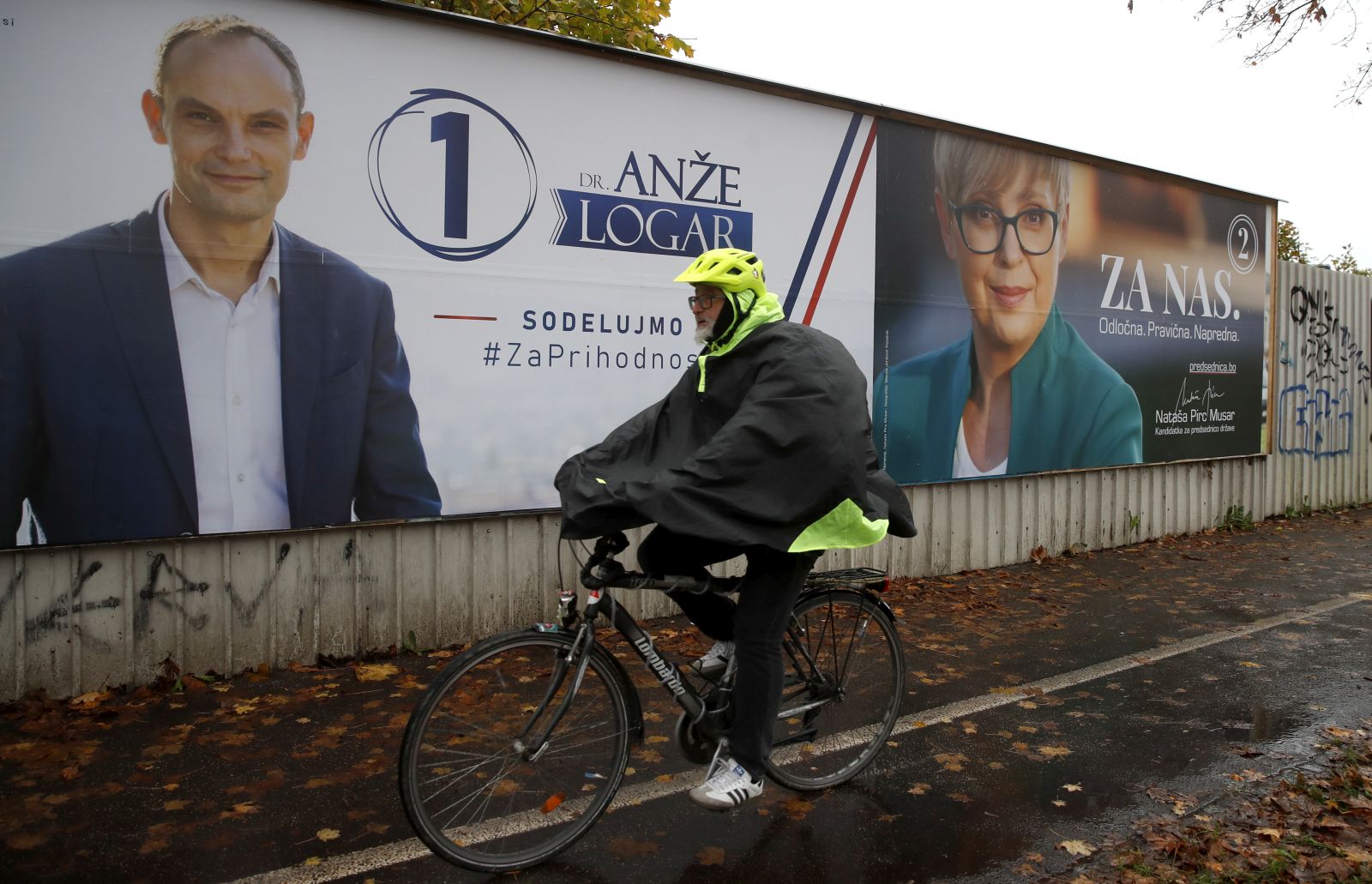 epa10298297 A man passes near huge pre-election posters of presidential candidates, Anze Logar and Natasa Pirc Musar, in downtown Ljubljana, Slovenia, 10 November 2022. The second round of the 2022 Slovenian presidential election takes place on 13 November between Anze Logar and Natasa Pirc Musar.  EPA/ANTONIO BAT