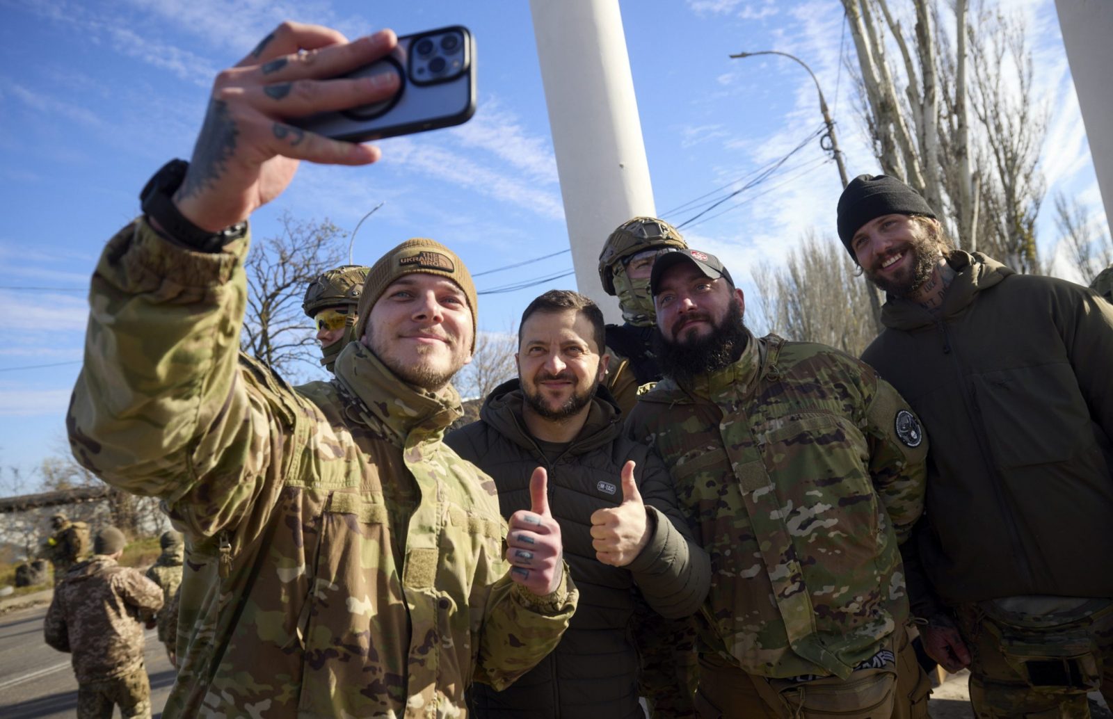 epa10305358 A handout photo made available by the Ukrainian presidential press service shows Ukrainian President Volodymyr Zelensky (C) posing for a selfie with servicemen as he visits the recaptured city of Kherson, Ukraine, 14 November 2022. Ukrainian troops entered Kherson on 11 November after Russian troops had withdrawn from the city. Kherson was captured in the early stage of the conflict, shortly after Russian troops had entered Ukraine in February 2022.  EPA/UKRAINE PRESIDENTIAL PRESS SERVICE HANDOUT HANDOUT HANDOUT EDITORIAL USE ONLY/NO SALES