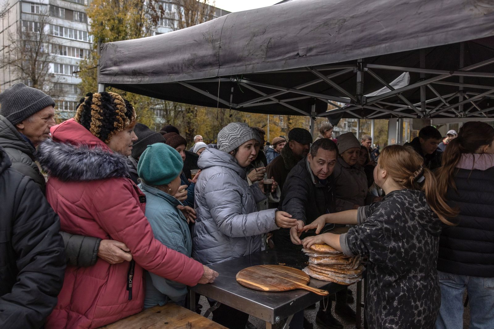 epa10328841 People wait in line to get pizzas from the volunteers, in Kherson, southern Ukraine, 24 November 2022 (issued 25 November 2022). Together with his volunteer team, Tom has been moving in vans all around Ukraine cooking free pizzas for people in need since the early stage of the Russian invasion. His team includes people from different countries, and every day they are able to make around three to four thousand pizzas, the ingredients for which they get from Italy. For now they will be volunteering in Kherson. Speaking about his plans Tom says he wants to keep working till the Ukrainian be victorous in the war.  EPA/ROMAN PILIPEY ATTENTION: This Image is part of a PHOTO SET