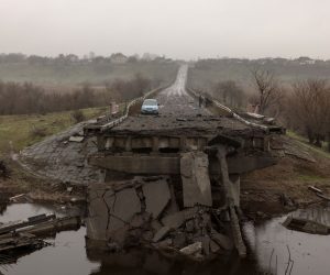 epa10331753 People (R, back) stand near a car on a destroyed bridge outside Kherson, southern Ukraine, 26 November 2022 (issued 27 November 2022). The Ukrainian president accused the Russian army of deliberately destroying critical infrastructure during their withdrawal from the city of Kherson, including electricity and water supplies. Ukrainian troops entered Kherson on 11 November after the Russian army had withdrawn from the city which they captured in the early stage of the conflict, shortly after Russian troops had entered Ukraine in February 2022.  EPA/ROMAN PILIPEY