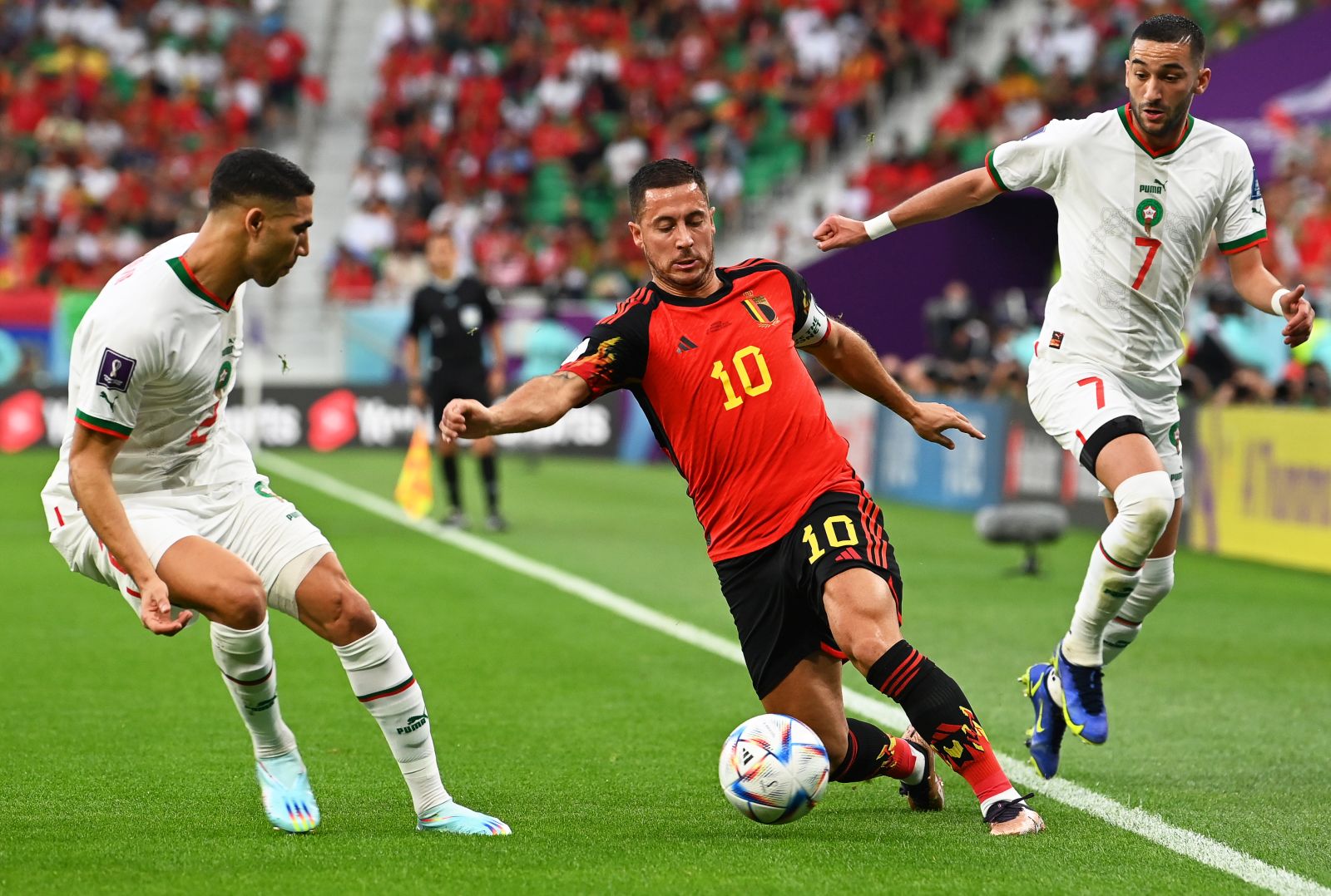epa10332053 Eden Hazard (C) of Belgium in action against Moroccan players Achraf Hakimi (L) and Hakim Ziyech (R) during the FIFA World Cup 2022 group F soccer match between Belgium and Morocco at Al Thumama Stadium in Doha, Qatar, 27 November 2022.  EPA/Georgi Licovski