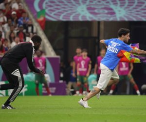 epa10335301 A steward (L) chases a pitch invader during the FIFA World Cup 2022 group H soccer match between Portugal and Uruguay at Lusail Stadium in Lusail, Qatar, 28 November 2022.  EPA/Abir Sultan