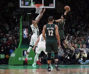 Boston Celtics forward Jayson Tatum (0) drives in for the slam dunk over Milwaukee Bucks forward Giannis Antetokounmpo (34) during the first half of an NBA basketball game, Sunday, Dec. 25, 2022, in Boston. (AP Photo/Mary Schwalm)