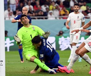 epa10337167 Christian Pulisic of the USA (C) collides with goalkeeper Alireza Beiranvand of Iran as he scores the 1-0 during the FIFA World Cup 2022 group B soccer match between Iran and the USA at Al Thumama Stadium in Doha, Qatar, 29 November 2022.  EPA/Neil Hall