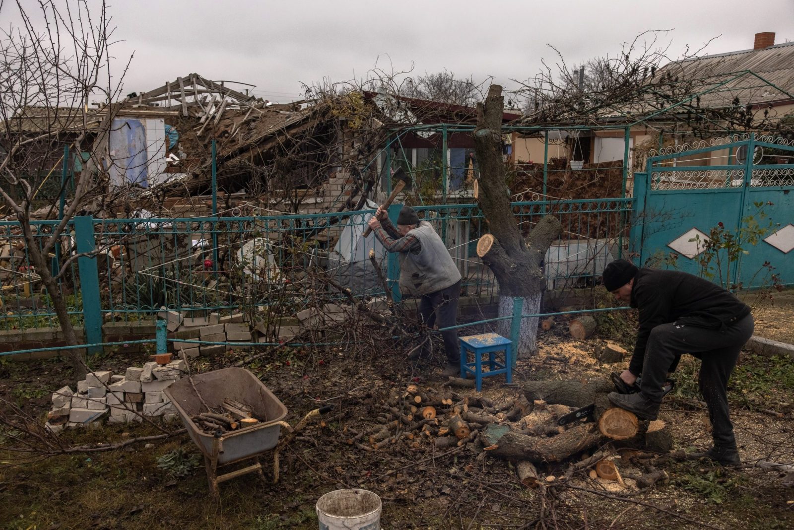 epa10339898 Victor Tsap(C) prepares wood for the winter season next to his destroyed house in the village of Pravdyne, outside Kherson, southern Ukraine, 30 November 2022. On its retreat from Kherson, the Russian army destroyed critical infrastructure in the city, including electricity and water supplies. Now, the constant Russian shellings, the lack of electricity, and running water in the town during the winter season has forced many locals to flee Kherson. Ukrainian troops entered Kherson on 11 November after the Russian army had withdrawn from the city which they captured in the early stage of the conflict, shortly after Russian troops had entered Ukraine in February 2022.  EPA/ROMAN PILIPEY