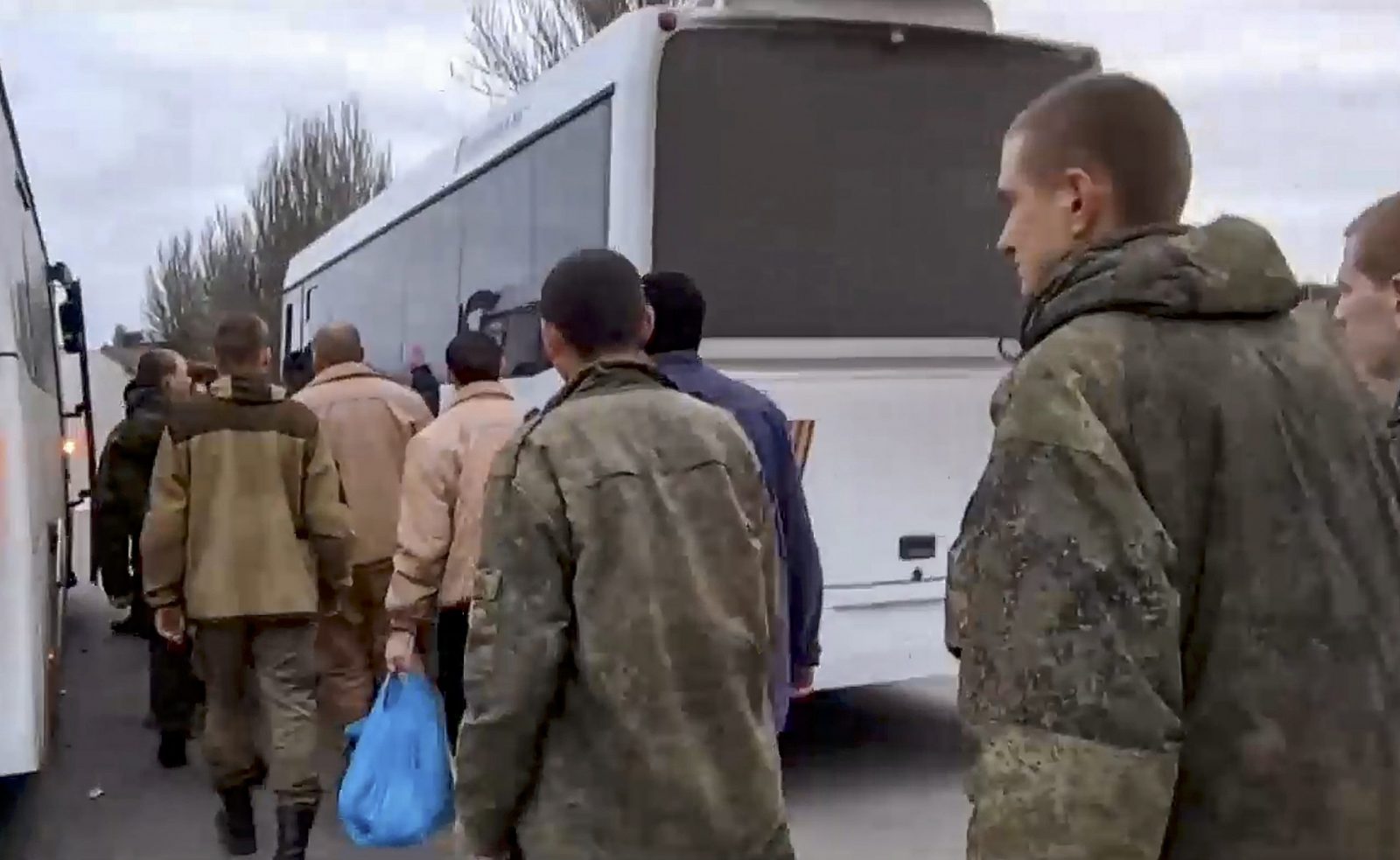 epa10326014 A handout still image taken from handout video provided by the Russian Defence ministry press-service shows a group of Russian servicemen former prisoners of war (POW) board to the buses after their exchange at the unknown location in Russia, 24 November 2022. The Russian Defense Ministry announced that 50 Russian servicemen, prisoners of war, returned to Russia after prisoners swap with Ukraine. To the Ukraine returned 50 Ukrainian servicemen.  EPA/RUSSIAN DEFENCE MINISTRY PRESS SERVICE / HANDOUT  HANDOUT EDITORIAL USE ONLY/NO SALES