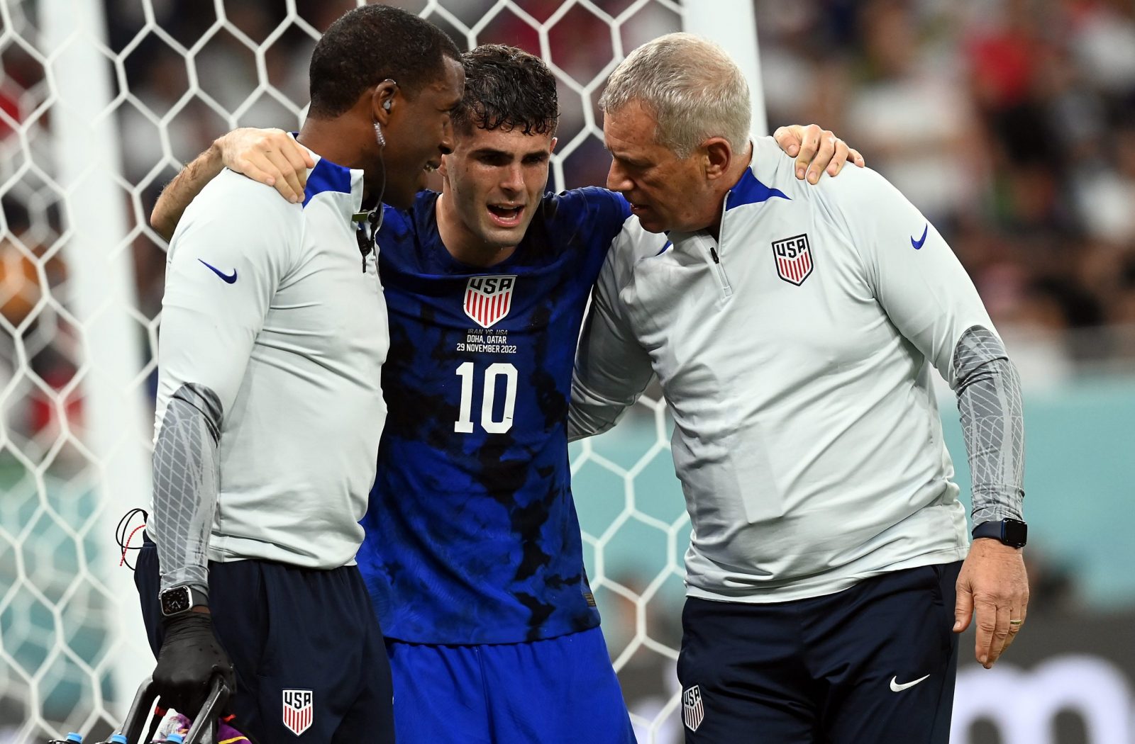 epa10337196 Christian Pulisic of the USA (C) gets assistance after colliding with goalkeeper Alireza Beiranvand of Iran as he scored the 1-0 during the FIFA World Cup 2022 group B soccer match between Iran and the USA at Al Thumama Stadium in Doha, Qatar, 29 November 2022.  EPA/Neil Hall
