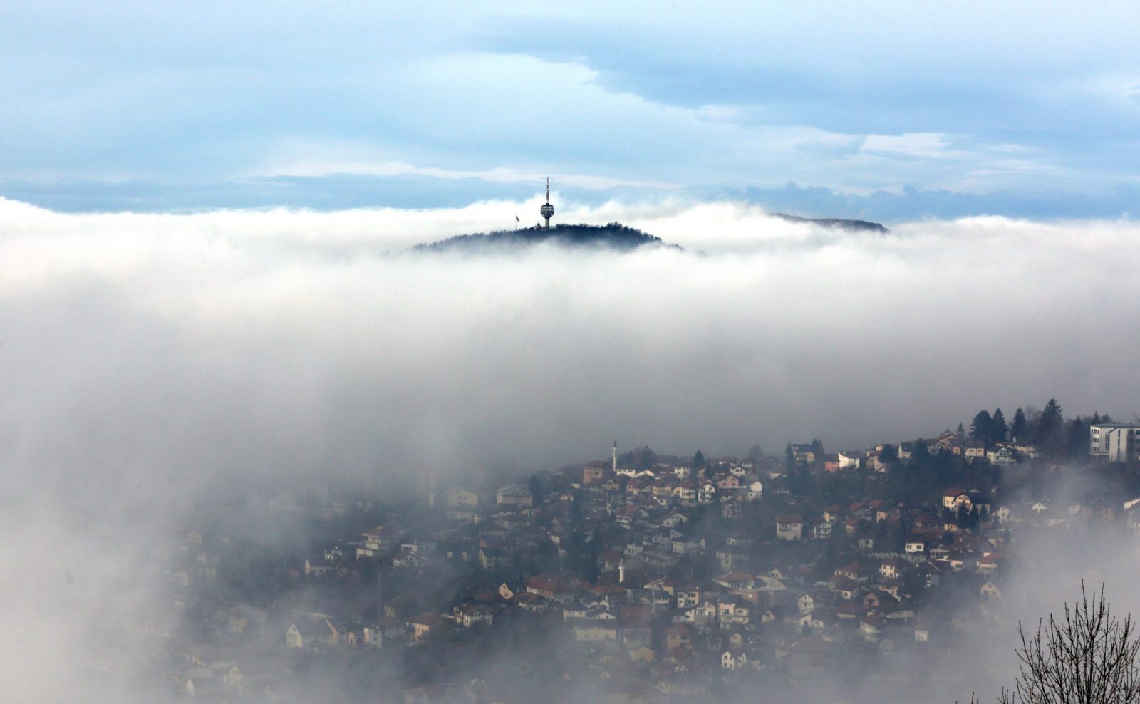 epa10345834 A television tower on a mountain peak pokes out of a low layer of fog covering the surroundings of the city of Sarajevo, Bosnia and Herzegovina, 03 December 2022. With an AQI (Air Quality Index) of 163, which is labelled as 'unhealty', the Bosinan capital is among the most polluted cities in the world, ranking on 6th place on 03 December 2022.  EPA/FEHIM DEMIR