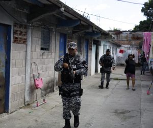 epa10346905 Salvadoran policemen patrol a street in Soyapango, El Salvador, 03 December 2022.Some 10,000 members of the Armed Forces and the National Civil Police (PNC) were deployed in the populous municipality of Soyapango to 'extract' gang members who have not yet been captured and continue the 'war against gangs'.  EPA/Rodrigo Sura