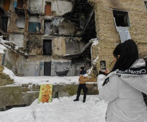 epa10347162 People take pictures near a damaged apartment block with a mural by street artist Banksy, depicting a man in a bathtub scrubbing his back with a brush (rear), in Horenka, near Kyiv, Ukraine, 03 December 2022. In November 2022, street artist Banksy painted a series of artworks in Ukraine, including at this building in Horenka, that was damaged by Russian shelling during combat in the Kyiv region last March. Russian troops on 24 February entered Ukrainian territory, starting a conflict that provoked destruction and a humanitarian crisis.  EPA/OLEG PETRASYUK