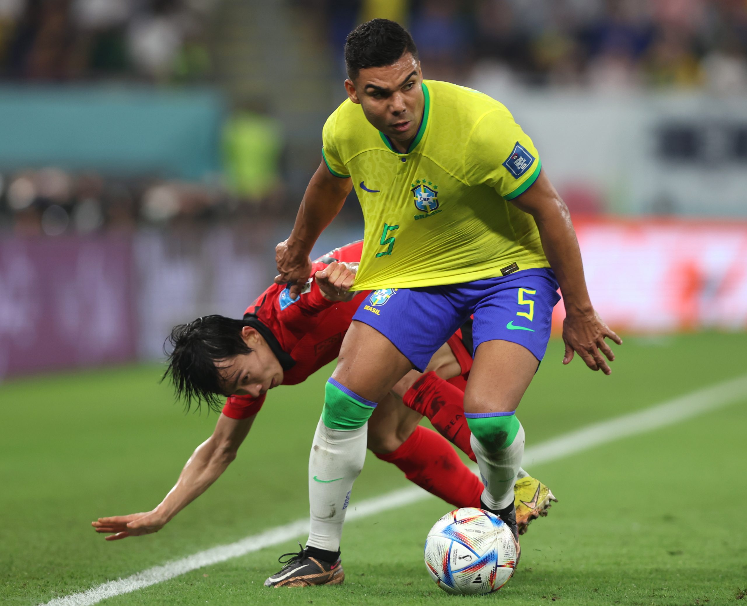 epa10350513 Casemiro (R) of Brazil in action against Moonhwan Kim of South Korea during the FIFA World Cup 2022 round of 16 soccer match between Brazil and South Korea at Stadium 974 in Doha, Qatar, 05 December 2022.  EPA/Tolga Bozoglu