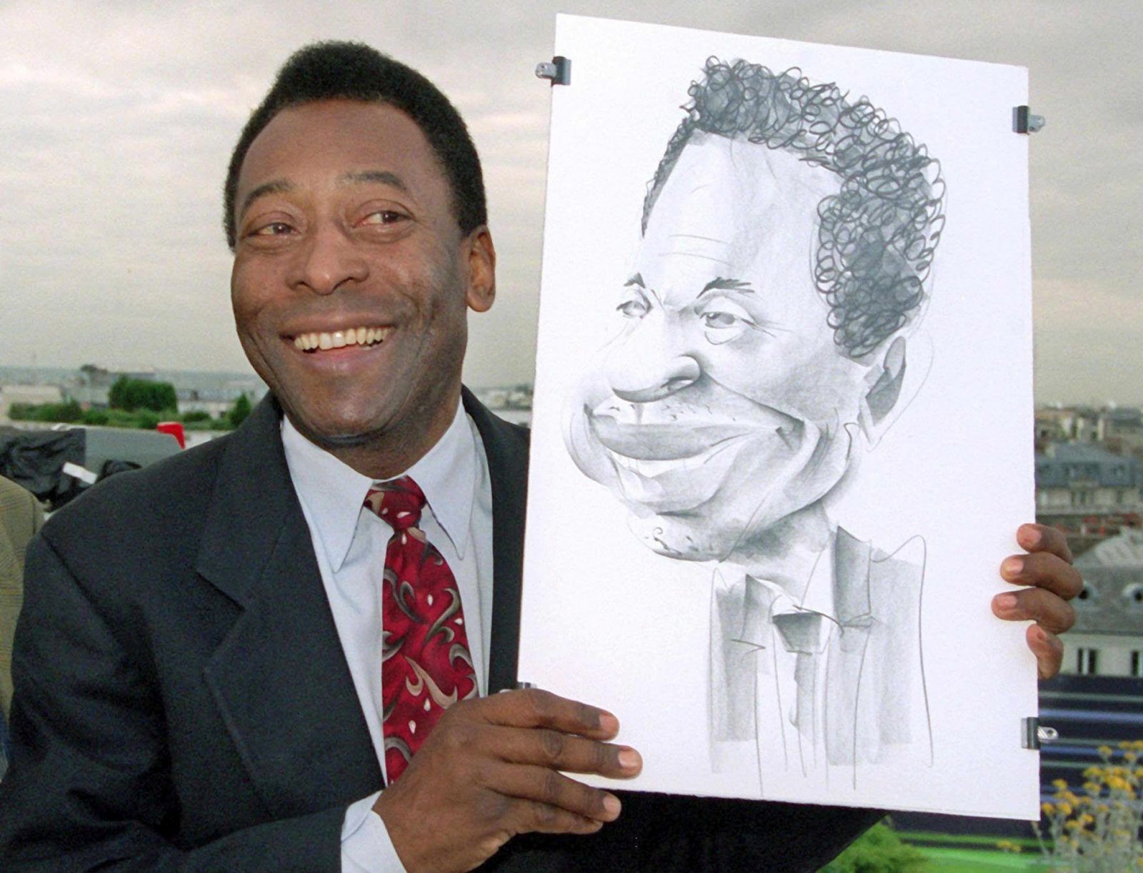 epa10381777 (FILE) - Brazilian soccer legend Pele poses with a caricature of himself at the German TV channel ZDF studio on the roof of a hotel, in Paris, France, 12 June 1998 (reissued 29 December 2022). According to his agent, Pele, whose proper name is Edson Arantes do Nascimento, has died on 28 December 2022 at age 82.  EPA/PETER KNEFFEL *** Local Caption *** 99427778