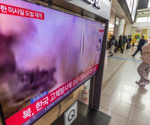 epa10383341 People walk past a television airing breaking news about North Korea's firing of three short-range ballistic missiles into the East Sea, at Seoul Station in central Seoul, South Korea, 31 December 2022.  EPA/YONHAP SOUTH KOREA OUT