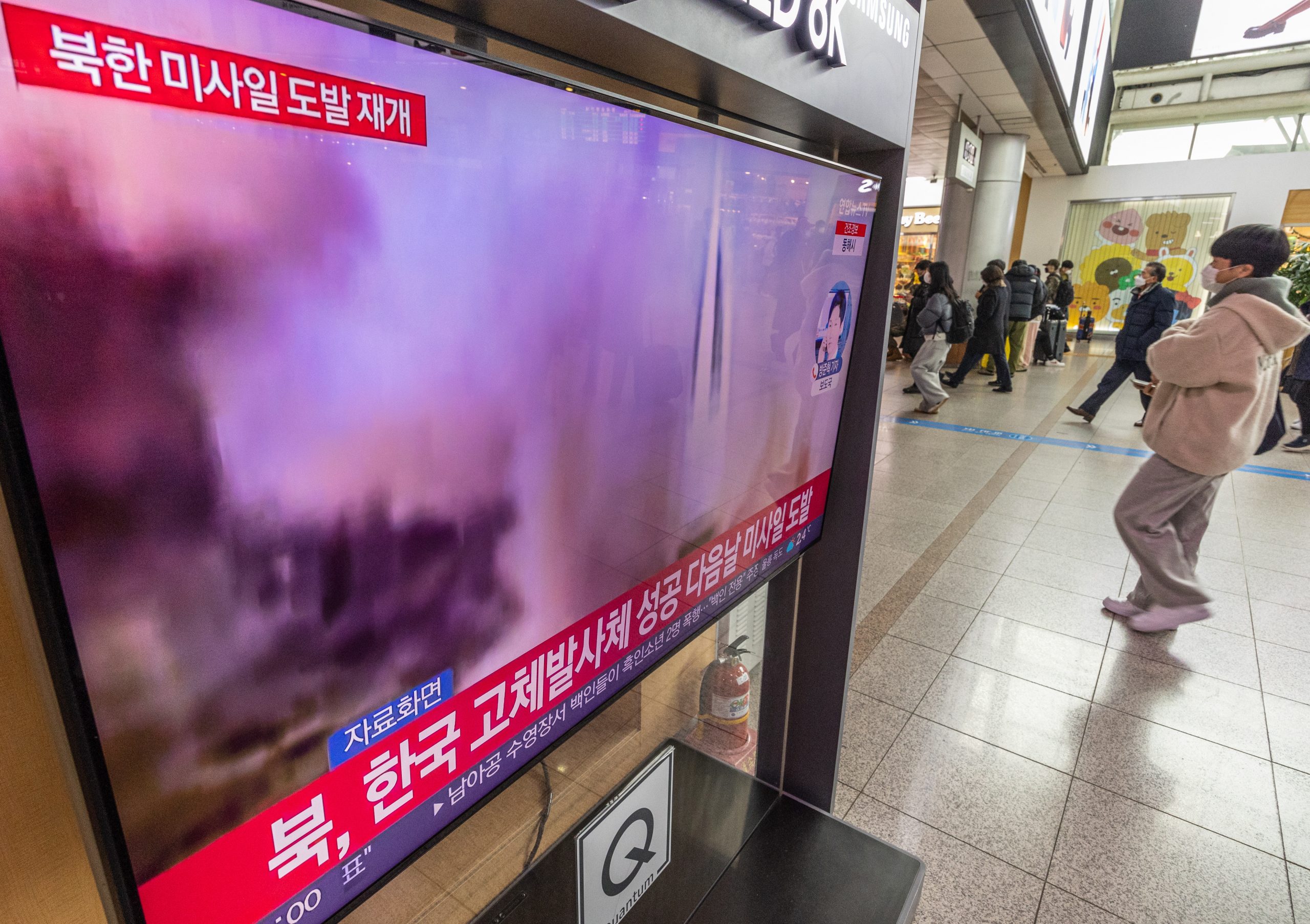 epa10383341 People walk past a television airing breaking news about North Korea's firing of three short-range ballistic missiles into the East Sea, at Seoul Station in central Seoul, South Korea, 31 December 2022.  EPA/YONHAP SOUTH KOREA OUT