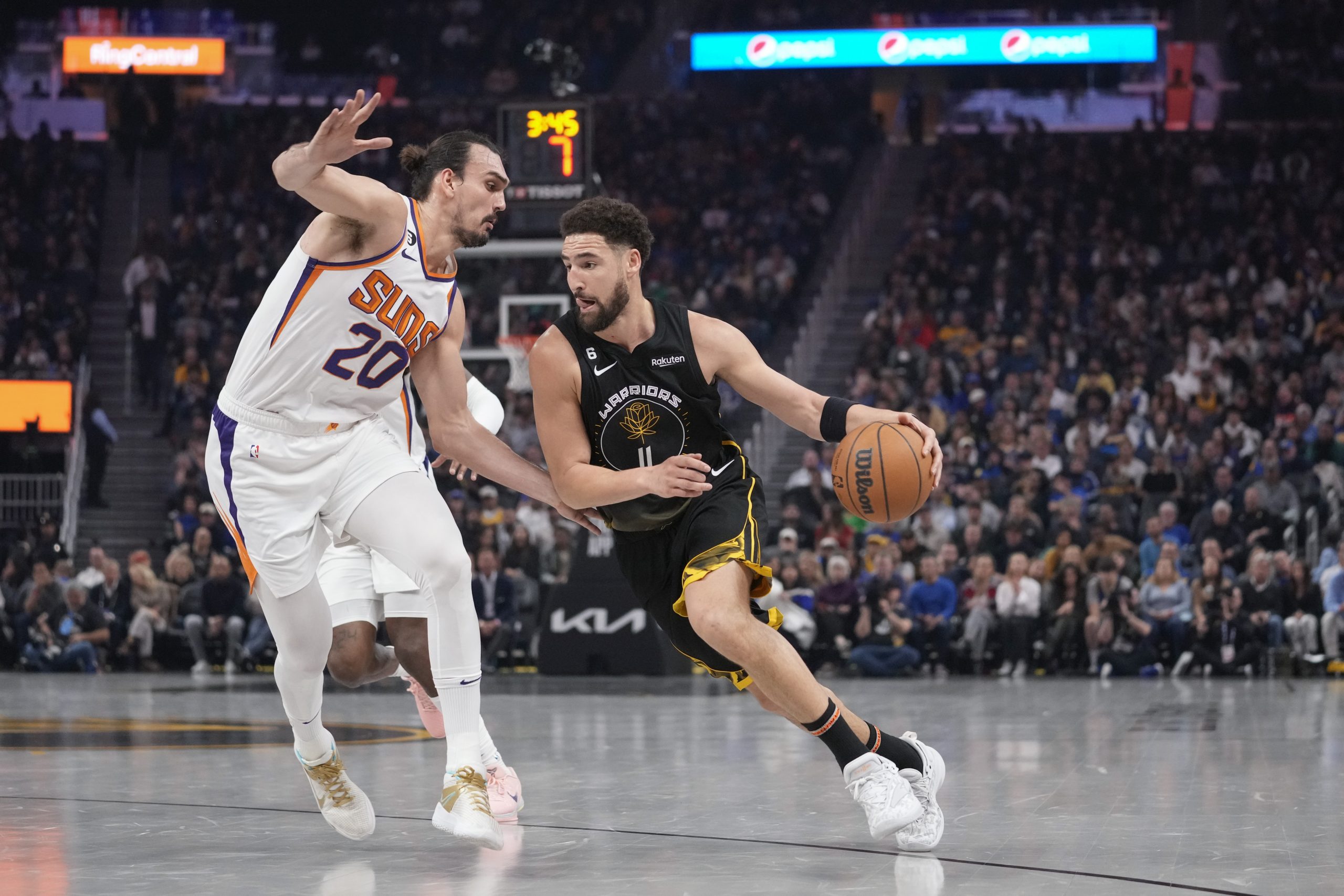 Golden State Warriors guard Klay Thompson (11) drives while defended by Phoenix Suns forward Dario Saric (20) during the first half of an NBA basketball game in San Francisco, Tuesday, Jan. 10, 2023. (AP Photo/Godofredo A. Vásquez)
