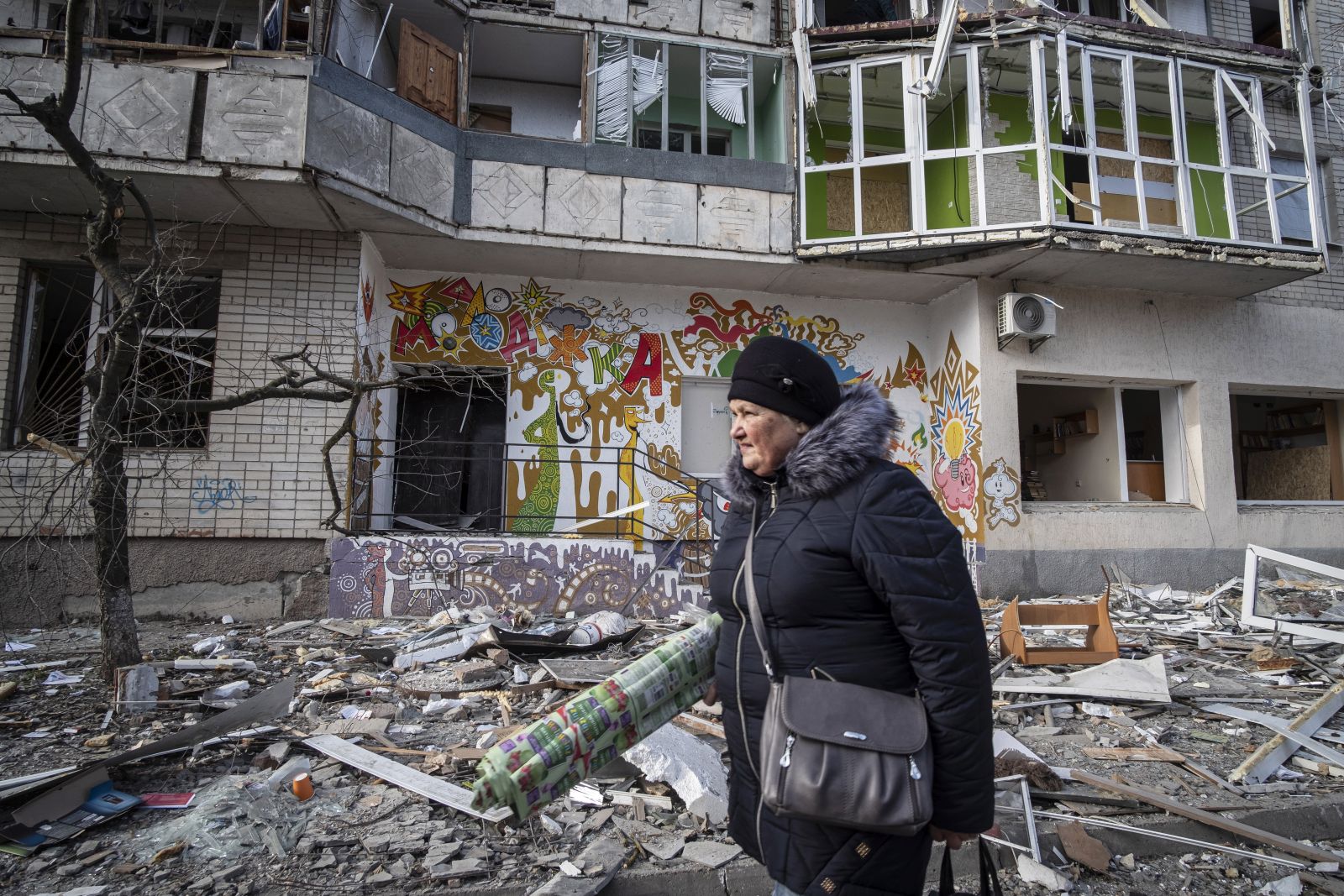 epa10375640 A resident passes a destroyed residential building following overnight shelling in Kherson, Ukraine, 21 December 2022. Ukrainian troops entered Kherson on 11 November after the Russian army had withdrawn from the city which they captured in the early stage of the conflict, shortly after Russian troops had entered Ukraine in February 2022. The Ukrainian president accused the Russian army of deliberately destroying critical infrastructure during their withdrawal from the city of Kherson, including electricity and water supplies.  EPA/Maria Senovilla
