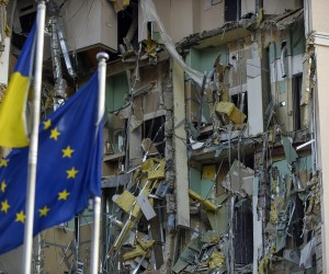 epa10383862 EU and Ukrainian flags fly in front of the damaged hotel building that was hit in a missile strrike in downtown Kyiv (Kiev), Ukraine, 31 December 2022. Russian missiles targeted major cities across Ukraine on 31 December prior to the New Year celebration. Kyiv Mayor Vitaliy Klitschko reported explosions and destruction in three districts of the capital. At least one person was killed, Klitschko said. Russian troops entered Ukraine on 24 February 2022 starting a conflict that has provoked destruction and a humanitarian crisis.  EPA/OLEG PETRASYUK