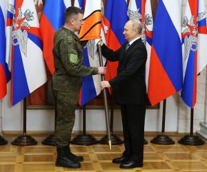 epa10384017 Russian President Vladimir Putin (R) presents the battle banners to an unidentified serviceman for the Donetsk and Luhansk Army Corps during his visit to the Southern Military District, as Russia's so-called "special military operation" continues, at an undisclosed location in Rostov region, Russia, 31 December 2022.  EPA/MIKHAEL KLIMENTYEV/SPUTNIK/KREMLIN POOL / POOL MANDATORY CREDIT