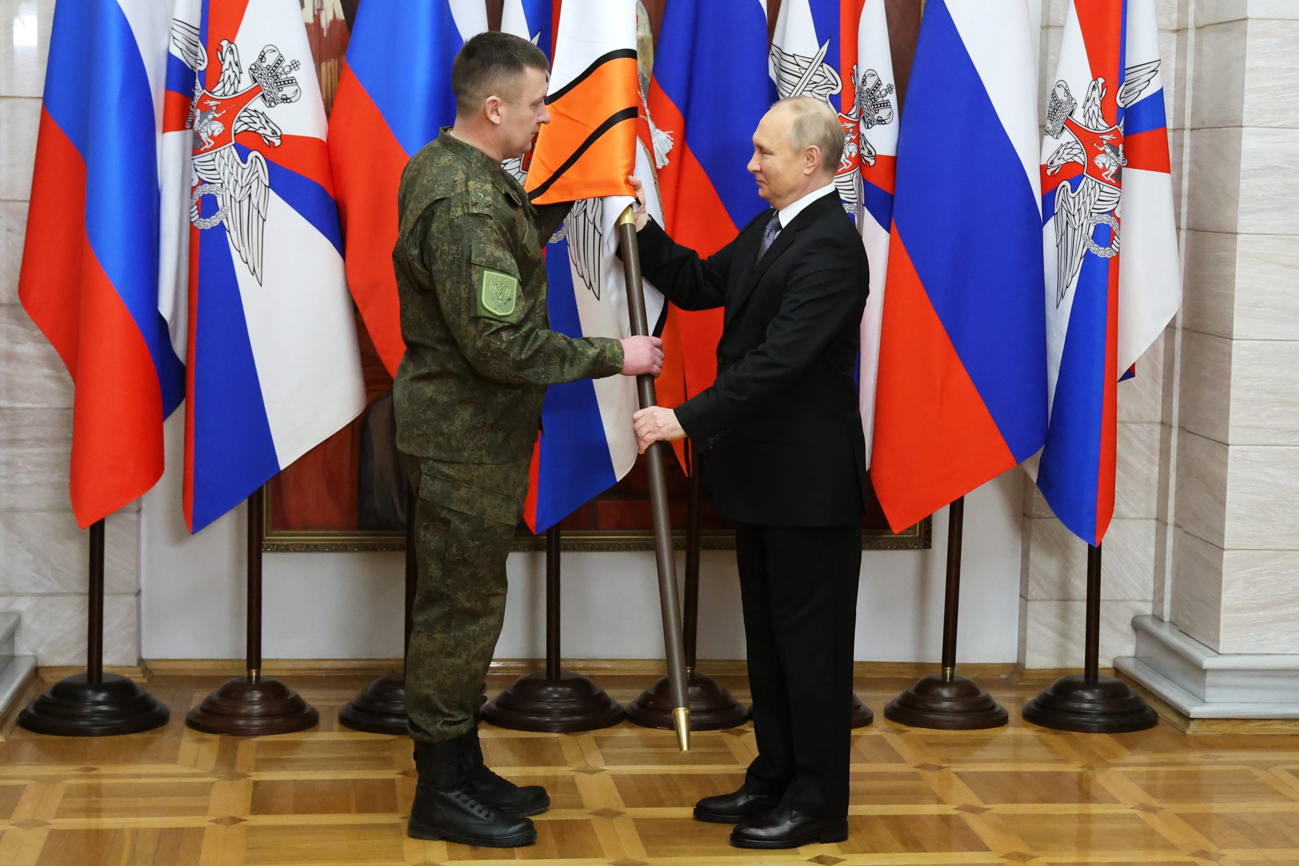 epa10384017 Russian President Vladimir Putin (R) presents the battle banners to an unidentified serviceman for the Donetsk and Luhansk Army Corps during his visit to the Southern Military District, as Russia's so-called "special military operation" continues, at an undisclosed location in Rostov region, Russia, 31 December 2022.  EPA/MIKHAEL KLIMENTYEV/SPUTNIK/KREMLIN POOL / POOL MANDATORY CREDIT