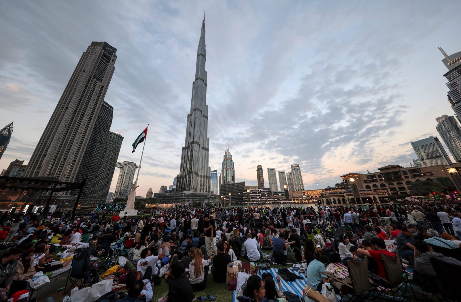 epa10384196 People wait near the Burj Khalifa the world's tallest building in the world, prior to the fireworks of New Year's Eve 2023 celebrations in the Gulf emirate of Dubai, United Arab Emirates, 31 December 2022.  EPA/ALI HAIDER