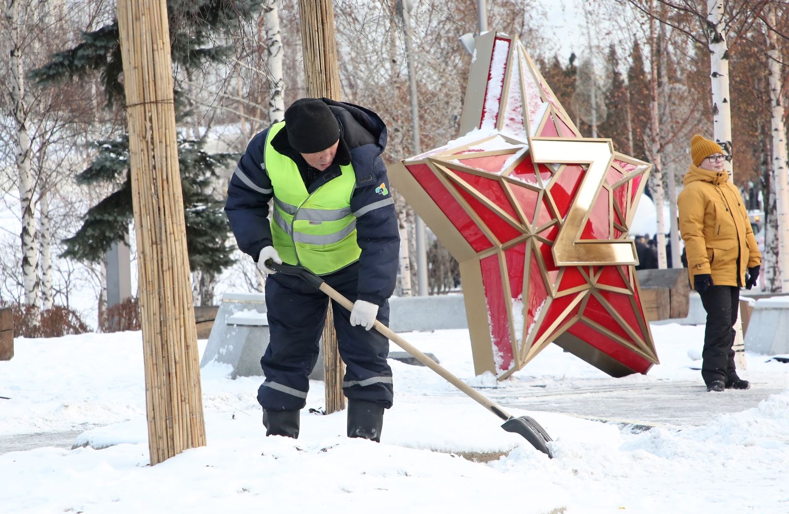 epa10390510 A municipal worker clears the Zaryadye Park after a snowfall, decorated for Christmas and the New Year with a letter Z in support of Russian army, in downtown Moscow, Russia, 05 January 2023. The temperature dropped -10 degrees Celsius in the Moscow region.  EPA/MAXIM SHIPENKOV