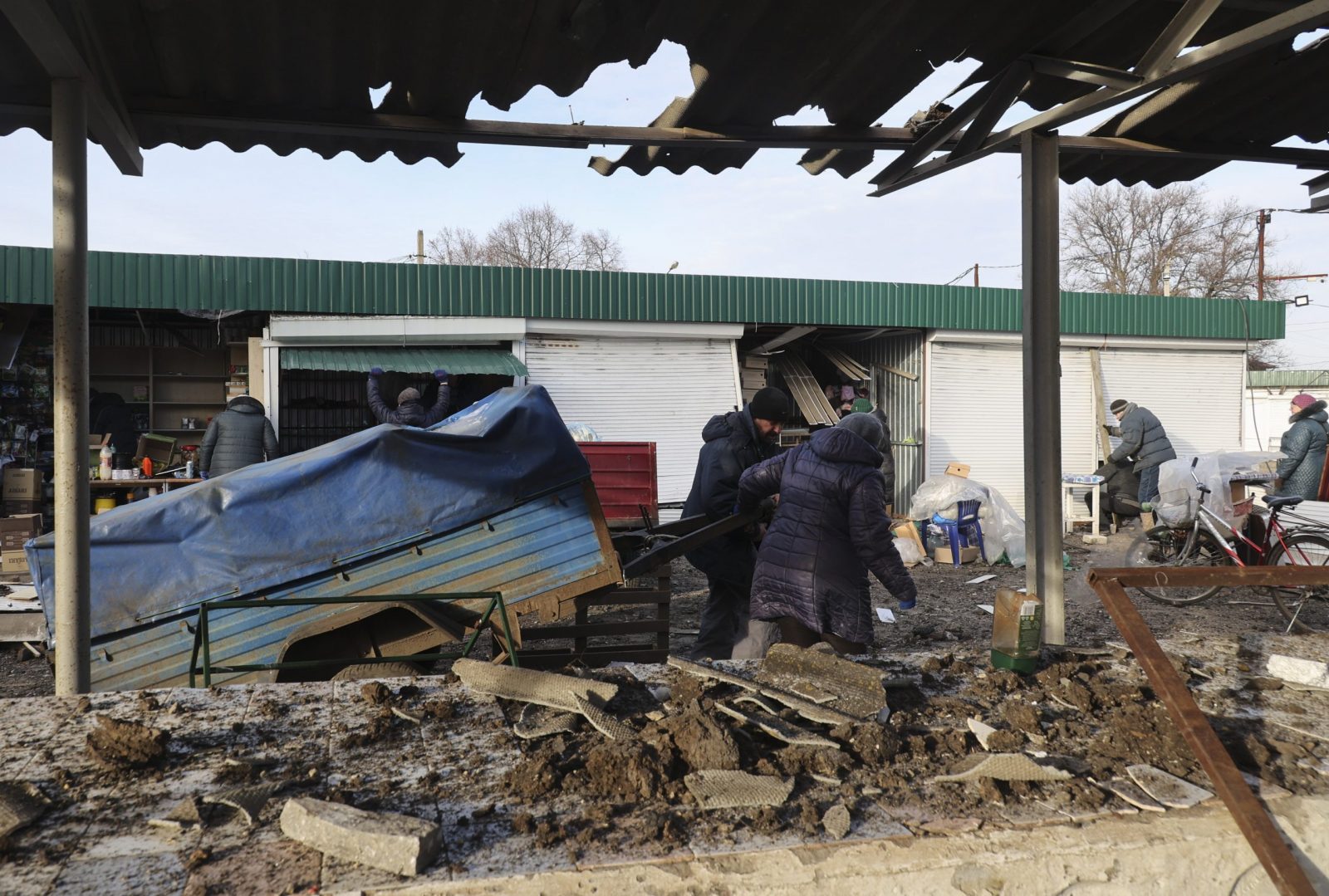 epa10397019 Ukrainians attempt to salvage goods at a damaged local market after shelling hit the town of Shevchenkove, Kharkiv region, northeastern Ukraine, 09 January 2023, amid Russia's invasion. Two people were killed and five others injured, among them a child, as a result of a rocket attack on Shevchenkive village in the Kupyansk district, the head of Kharkiv Regional State Administration Oleh Synehubov wrote on telegram. Russian troops on 24 February 2022, entered Ukrainian territory, starting a conflict that has provoked destruction and a humanitarian crisis.  EPA/SERGEY KOZLOV