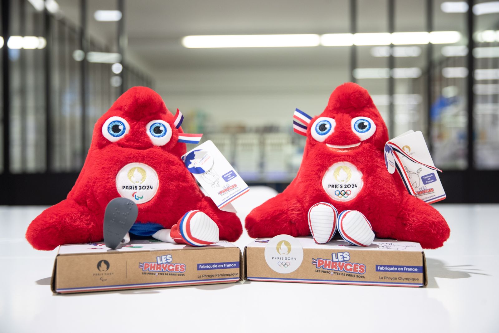 epa10402600 Two different examples, paralympic and not, of the Phrygian, the mascot of the Olympic Games Paris 2024, sit on a table in the factory of the group Doudou et Compagnie in La Guerche de Bretagne, France, 11 January 2023 (issued 13 January 2023). The Doudou et Companie group, specializing in the manufacture of plush toys since 1999, has begun producing the phrygians, the mascots of the Paris 2024 Olympic Games in January 2023. The design of the mascot is inspired by the Phrygian, a cap used during the French revolution. The group is looking to increase the number of seamstresses, from 23 to 50, in order to face the challenges of craft manufacturing, which aims to make more than 500 plush toys per day in full production. The group is responsible for the production of 60 percent of the mascot collections, of which 20 percent will be produced in France, representing 400,000 mascots.  EPA/TERESA SUAREZ
