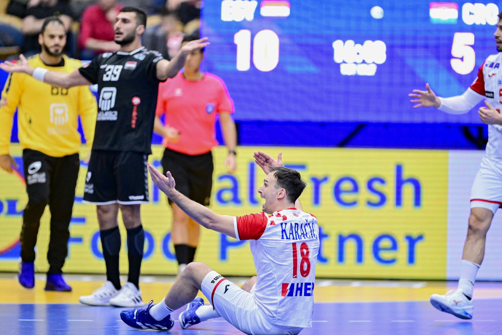 epa10403693 Croatia's Igor Karacic (down) and Egypt's Yehia Elderaa (L) argue with the referee during the IHF Men's World Championship group G handball match between Egypt and Croatia, at Husqvarna Garden in Jonkoping, Sweden, 13 January 2023.  EPA/Mikael Fritzon SWEDEN OUT