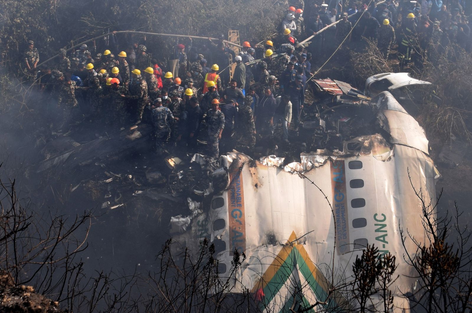 epa10406959 Rescue teams working near the wreckage at the crash site of a Yeti Airlines ATR72 aircraft in Pokhara, central Nepal, 15 January 2023. A Yeti Airlines ATR72 aircraft carrying 72 people on board, 68 passengers and 4 crew members, crashed into a gorge while trying to land at the Pokhara International Airport. According to a statement from the Civil Aviation Authority of Nepal (CAAN), at least 68 people were confirmed dead.  EPA/KRISHNA MANI BARAL
