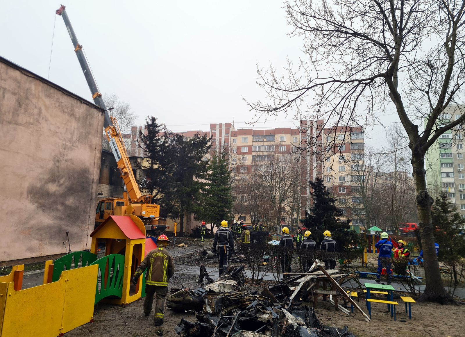 epa10412803 Rescue services work at the scene of a helicopter crash in Brovary, near Kyiv, Ukraine, 18 January 2023. At least 18 people died, including three children, after a helicopter crashed near a kindergarten and a residential building in the city of Brovary, Oleksiy Kuleba, the head of Kyiv Regional Military Administration wrote on telegram. A rescue operation was underway at the site, he added. As a result of the crash, the leadership of the Ministry of Internal Affairs died: the minister, the first deputy minister and the state secretary, according to the chief of Ukraine's National Police, Ihor Klymenko.  EPA/SERGEY DOLZHENKO